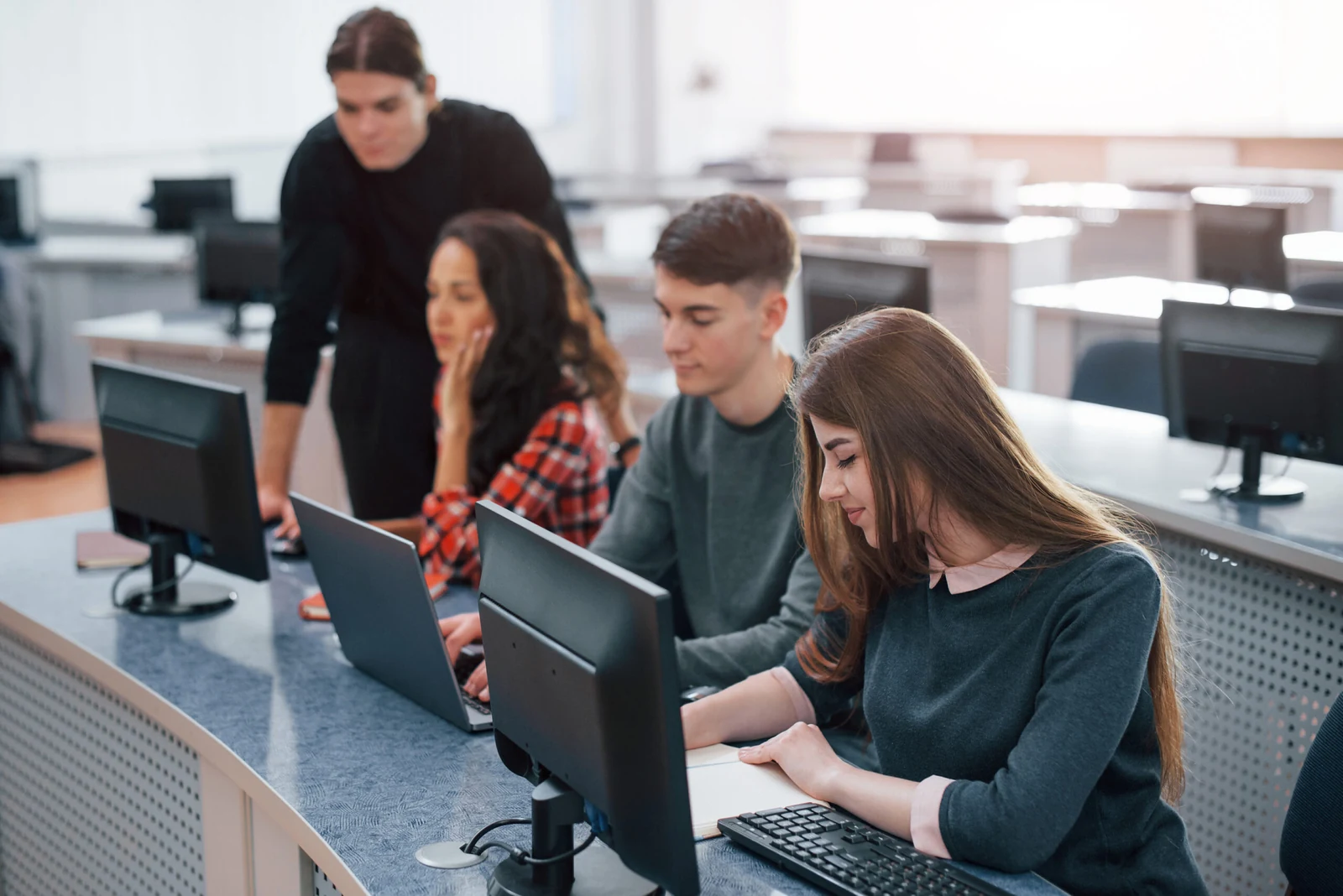 Schülerinnen und Schüler arbeiten in einem Computerraum